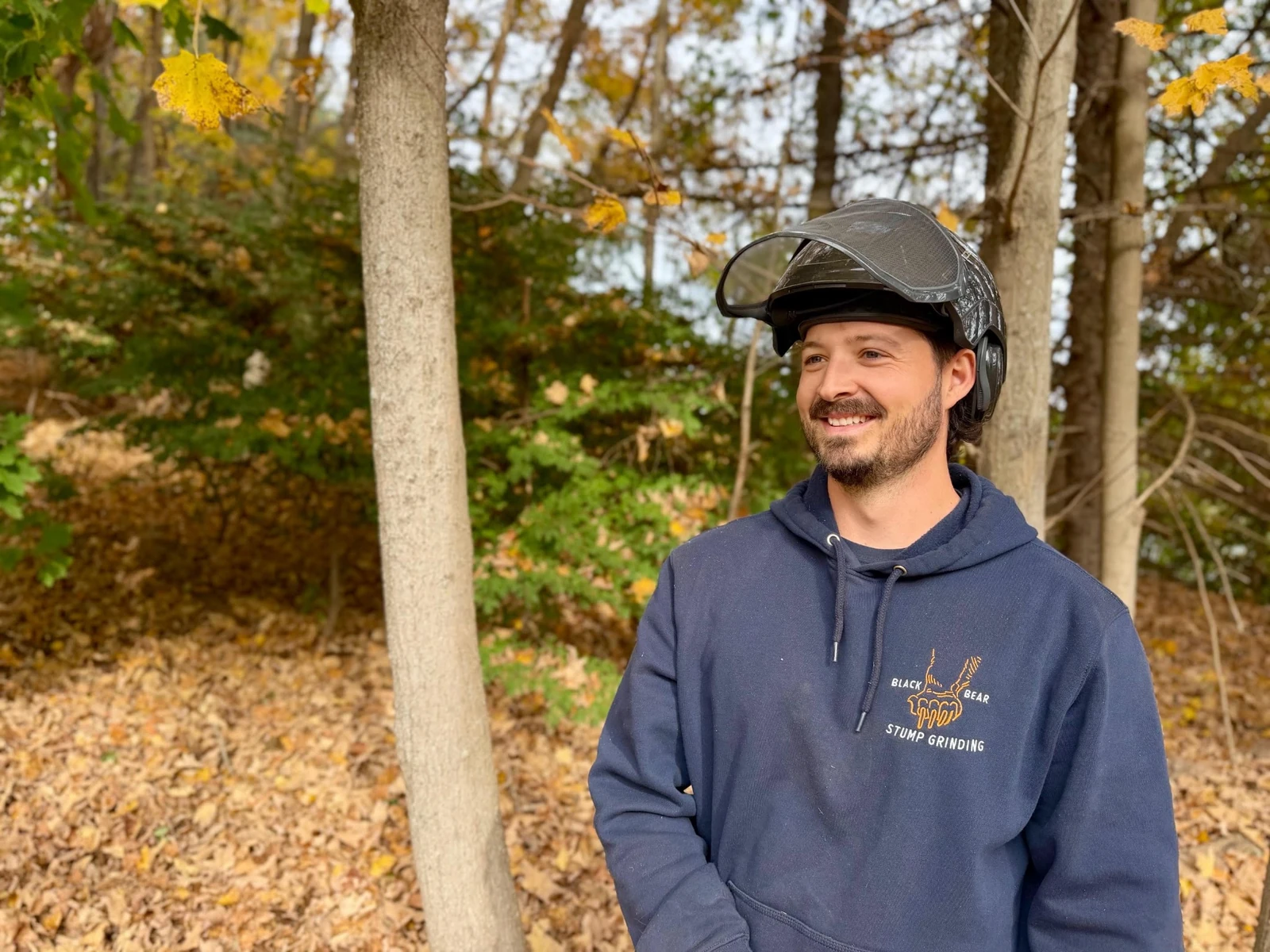Alex, owner of Black Bear Stump Grinding, wearing his Black Bear hoodie and protective face shield
